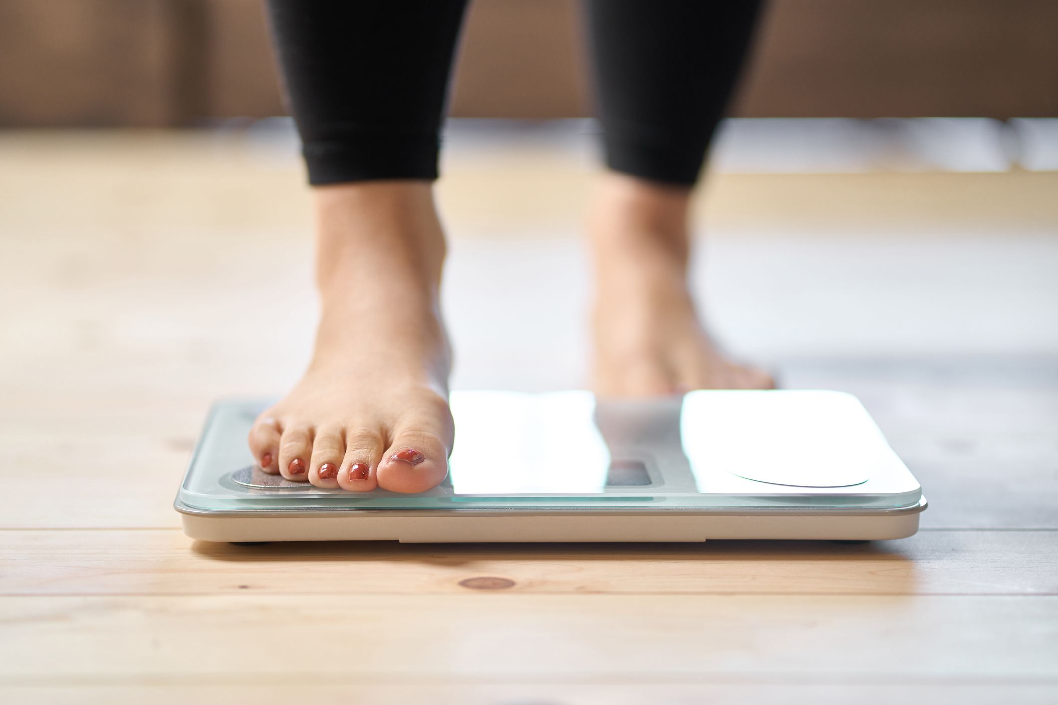 Image shows woman on scales